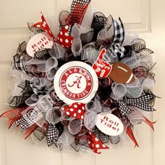 a wreath that is hanging on the front door with footballs and ribbon around it