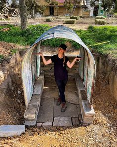 a woman standing in the entrance to a tunnel