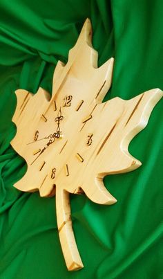 a clock made out of wood on a green cloth