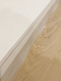 a close up view of a white table with wood grain on the bottom and sides