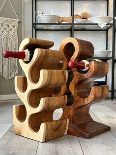 a wine rack made out of wood with two bottles on it and one bottle in the middle