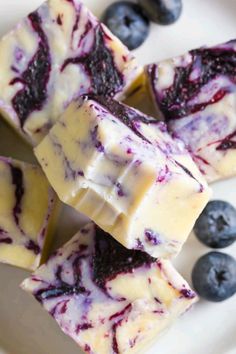 blueberry cheesecake fudges on a plate with fresh berries