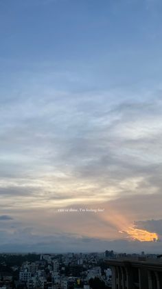 the sun is setting behind some clouds in the sky over a large cityscape