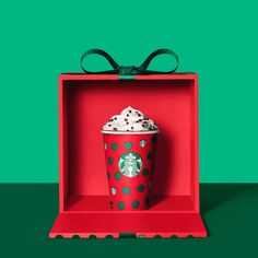 a starbucks cup in a red box with green polka dots and a bow on top