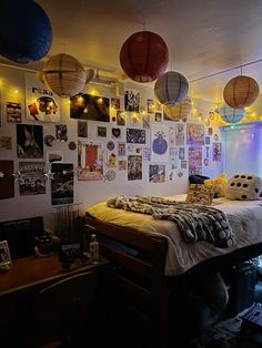 a bed room with a neatly made bed and lots of hanging decorations on the wall