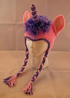 a pink and purple knitted hat with a unicorn horn