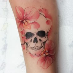 a skull and flowers tattoo on the leg