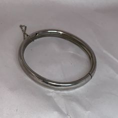 Vintage Silver Cuff Bangle Bracelet With Chain Catch. This Bracelet Measures 8 1/2" In Diameter, And 2 1/2" Across Once Closed. It Is 4.96mm Thick And 8.45mm Wide. This Bracelet Weighs 18.22 Grams. This Bracelet Has A 2 3/4" Chain Catch. Silver Stainless Steel Bangle With Polished Finish, Silver Oval Cuff Bracelet, Silver Nickel-free Bangle, Vintage Stainless Steel Bracelet Jewelry, Silver Hoop Bangle For Gift, Classic White Gold Metal Bangle, Vintage Stainless Steel Bracelet, Nickel-free Silver Stainless Steel Cuff Bracelet, Silver Sterling Silver Oval Cuff Bracelet