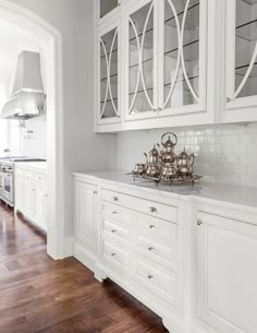 an image of a kitchen with white cabinets and wood flooring on the bottom row