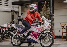 a person on a motorcycle parked in front of a building