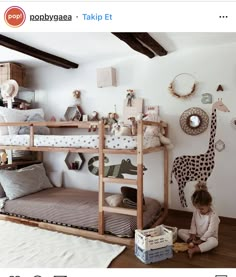 a child is sitting on the floor in front of bunk beds with giraffes