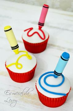 three cupcakes decorated with fondant and colored icing