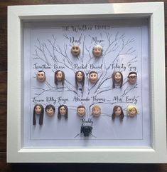 a family tree with dolls in it on a wooden table next to a framed photo