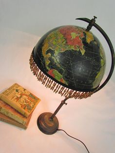 an old fashioned globe and some books on a table