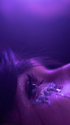 a close up of a person's eye with glitter on it