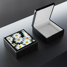 a black box with white and yellow daisies in it