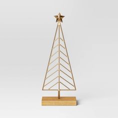 a gold metal christmas tree on a wooden base with a star decoration in the middle