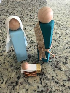 two wooden figures sitting on top of a counter