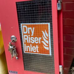 a red door with a sign that says dry riser inlet