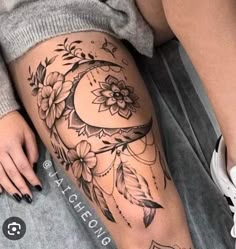 a woman's leg with tattoos and flowers on it