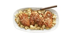 meatballs and macaroni on a white plate with a wooden serving utensil