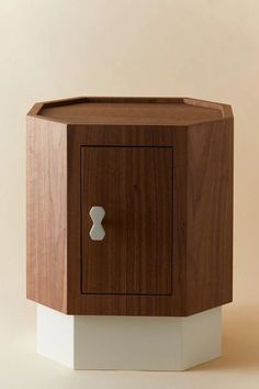 a wooden cabinet with a white base and knob on the front door, against a beige background