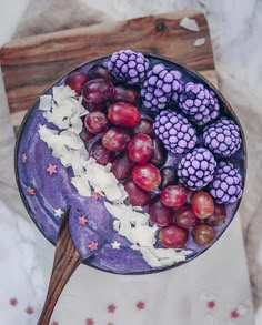 a bowl filled with grapes and other fruits