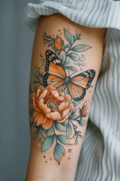 a butterfly and flower tattoo on the leg