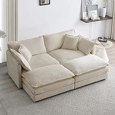 a white couch sitting on top of a rug in a living room next to a window