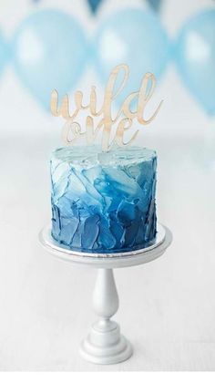 a cake with blue frosting and gold lettering on top