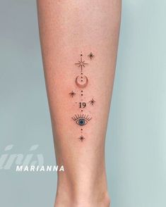 a woman's leg with an eye and stars tattoo on the bottom of it