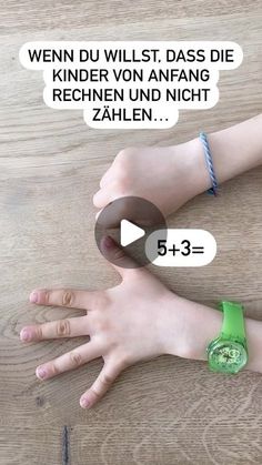 two hands with wristbands on top of a wooden table next to each other