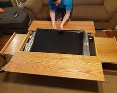 a man working on an open drawer in a living room