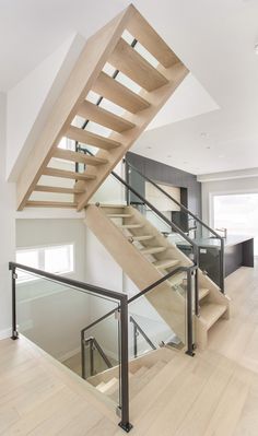 a wooden stair case with glass balconies on the bottom and handrails