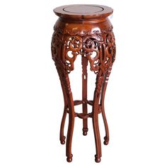 an ornate wooden stool with a round seat on it's legs and foot rest