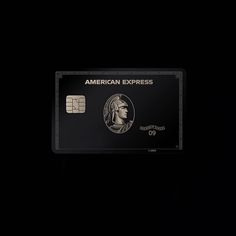 an american express credit card is shown in the dark, with a black background and white lettering