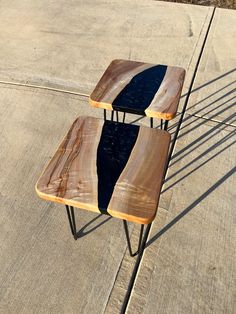 two wooden benches sitting next to each other on top of a cement flooring area