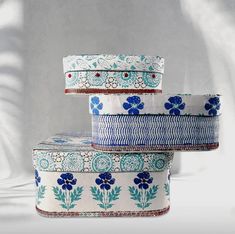 three boxes are stacked on top of each other with blue flowers and leaves painted on them