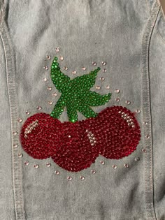 a jean jacket with sequins and cherries on it