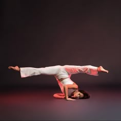 a woman is doing a handstand on the floor