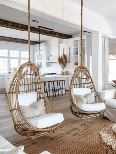 a living room filled with white furniture and hanging chairs