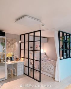 a bedroom with a bed, desk and mirror on the wall next to an open window