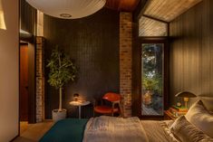 a bedroom with a brick wall and wooden ceiling, along with a large bed in the middle