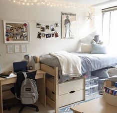 a dorm room with a bed, desk and computer