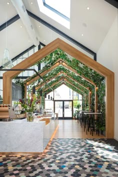 the inside of a restaurant with plants growing on the walls and tables in front of it