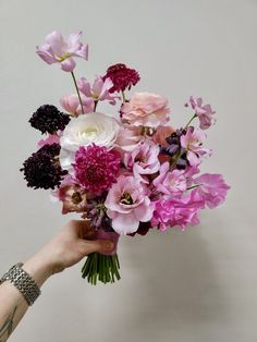 a person holding a bouquet of flowers in their hand