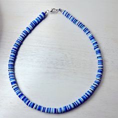 a blue and white beaded necklace sitting on top of a table