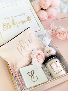 an open box with personal items inside it on a table next to flowers and candles