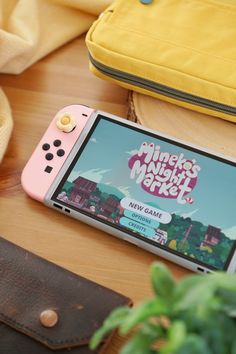 a pink nintendo switch sitting on top of a wooden table