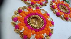 three decorative plates with orange and pink pom poms on top of each other